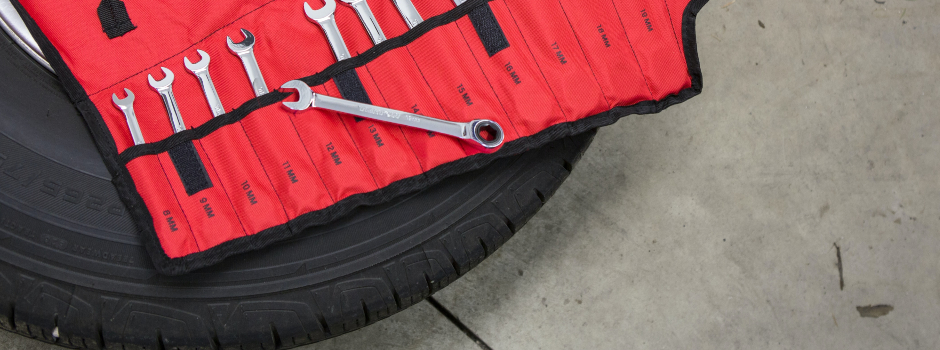 spanner set in red case on top of car wheel